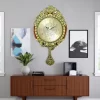 ساعة حائط فاخرة بتصميم كلاسيكي أنيق. تتميز بإطار مزخرف بنقوش يدوية معقدة وأرقام عربية. تأتي الساعة مع بندول يتأرجح برشاقة. مثالية لغرفة المعيشة أو مكتب العمل.