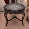 ترابيزة جانبية دائرية مصنوعة من خشب الزان مع زخارف نحاسية وتصميم كلاسيكي فرنسي. سطح الطاولة مصنوع من الزجاج الشفاف.
