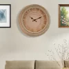 ساعة حائط أنيقة بتصميم كلاسيكي، تتميز بإطارها الخارجي المزين بنقوش رفيعة وعقاربها السوداء الأنيقة. وجه الساعة باللون البيج الفاتح مع أرقام رومانية واضحة، مما يضفي لمسة من الرقي والأناقة على أي غرفة.