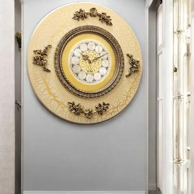 ساعة حائط أنيقة باللون الأبيض الكريمى بتصميم كلاسيكي فاخر يناسب الذوق الرفيع ومحبي التحف الفنية. تأتي الساعة بشكل دائري مميز مع إطار بتفاصيل زخرفية مذهلة ونقوش فنية تضيف لمسة من الفخامة والجمال.