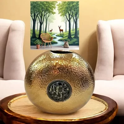 الفازة الذهبية التي أمامنا تتميز بتصميم بيضاوي فريد يجمع بين الأناقة والبساطة. وهي مصنوعة من البورسلين عالي الجودة، مما يضفي عليها ملمسًا ناعمًا ومظهرًا لامعًا. الفازة مزينة بنقوش معدنية دائرية بارزة بلون نحاسي، يمثل زخرفة نباتية تتكون من أوراق وأزهار. مثالية كقطعة ديكور أو كمزهرية.