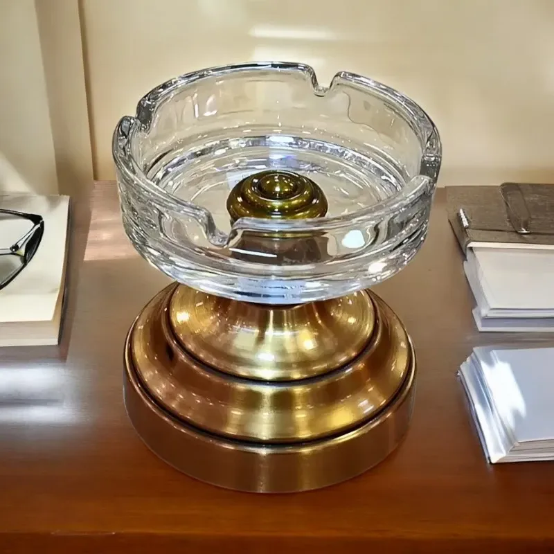 طفاية كريستال دائرية، قطر 10 سم، موديل 022663 منفضة سجائر أنيقة مصنوعة من الكريسنال الشفاف وقاعدة معدنية بكلاء نحاسي، مثالية للديكور المنزلي أو كهدية.