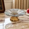 طبق فواكه من الكريستال الفاخر ذو قاعدة معدنية لامعة نحاسية اللون. يتميز هذا الوعاء بتصميمه المنحوت الجميل. مثالي لعرض الفواكه الطازجة أو الحلويات أو كقطعة ديكور جذابة.