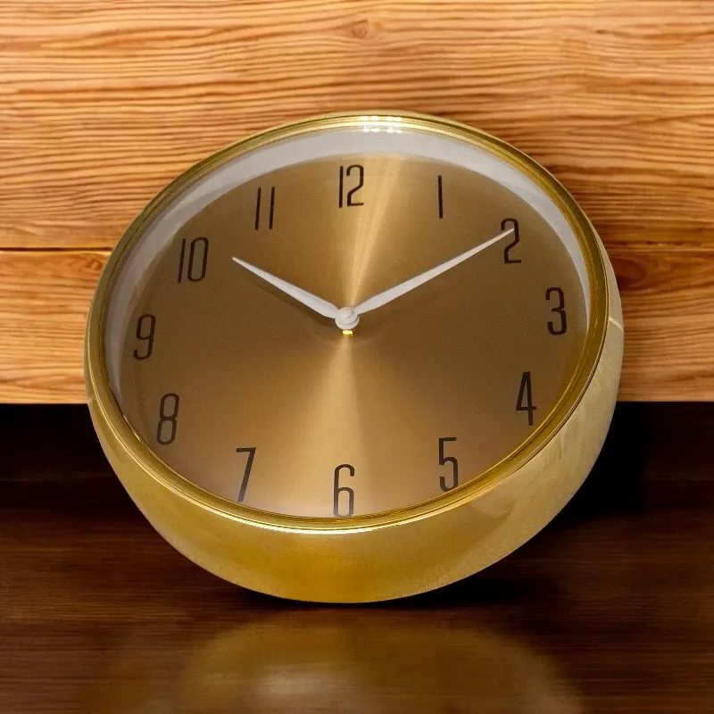 ساعة حائط ذهبية دائرية أنيقة، قطر 35 سم، موديل 029107 صورة لساعة حائط ذهبية دائرية أنيقة، ميناء ذهبي، أرقام سوداء، عقارب بيضاء.