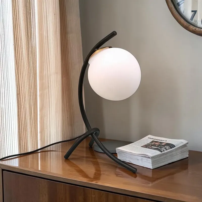 أباجورة معدنية بكلوب مضيء - تصميم عصري أنيق، موديل 027580 أباجورة معدنية سوداء بتصميم عصري أنيق مع كلوب زجاجي أبيض على بوفيه.