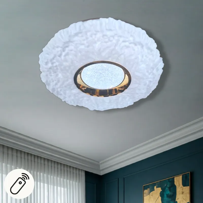 طبق إضاءة ليد دائري للسقف، ثلاثي الألوان مع إضاءة سهاري وريموت تحكم، قطر 50 سم، موديل 029906 طبق سقف LED أبيض ذو ملمس مع قرص ذهبي مركزي وإضاءة متلألئة، يظهر معه جهاز تحكم عن بعد في الزاوية السفلية اليسرى.