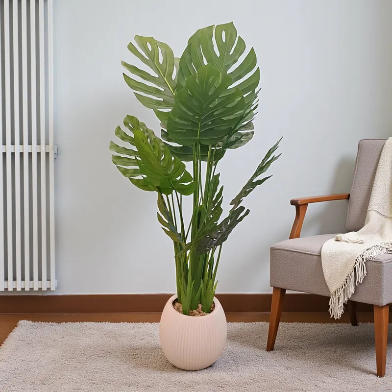 إخوان سرور الإضاءة الحديثة والديكور شجرة مونستيرا صناعية كبيرة وواقعية في وعاء أنيق، موضوعة بجانب أريكة عصرية في غرفة معيشة، لإضفاء لمسة ديكور طبيعية وأنيقة.